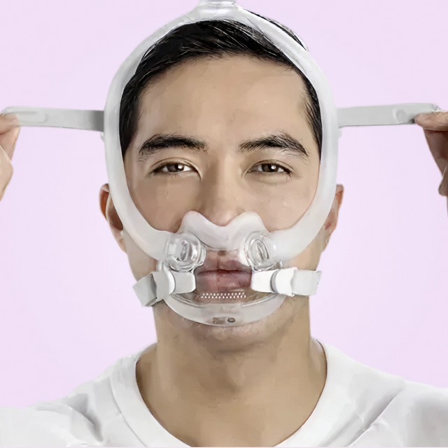 Close up front view of a man adjusting his ResMed AirFit™ F30i Full Face Mask