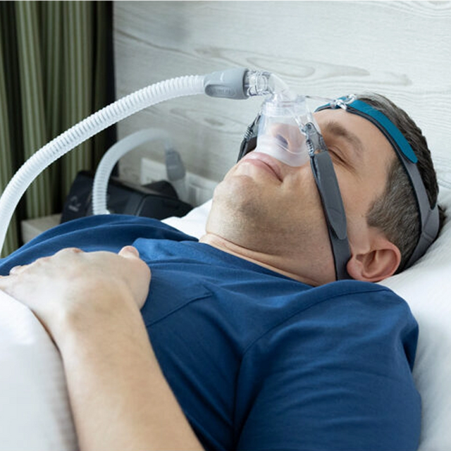 Man using a Löwenstein Cara Nasal CPAP Mask while lying in bed
