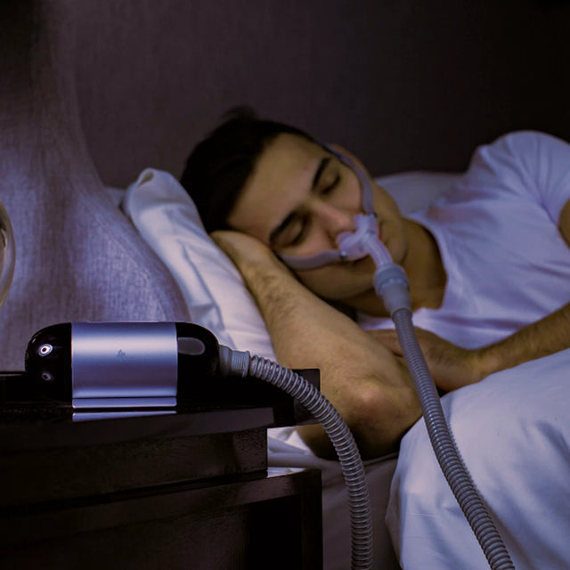 Sleeping man using BMC M1 Mini Automatic Travel CPAP Machine