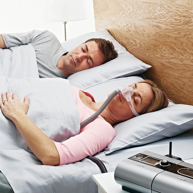Couple in bed sleeping, the woman wearing ResMed Swift FX Nano Nasal CPAP Mask For Her