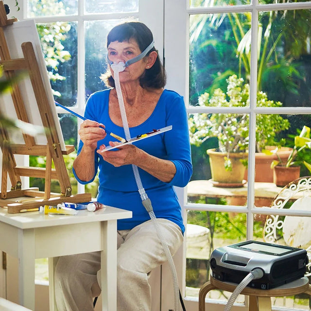 Woman painting while using ResMed Astral 150 Ventilator