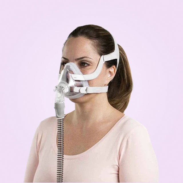 Woman wearing a ResMed AirFit™ F20 For Her - Full-Face CPAP Mask with a pink background