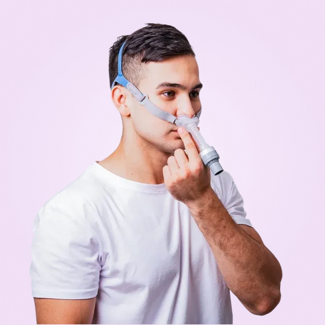 Man wearing a BMC P2 Nasal Pillow CPAP Mask on a pink background