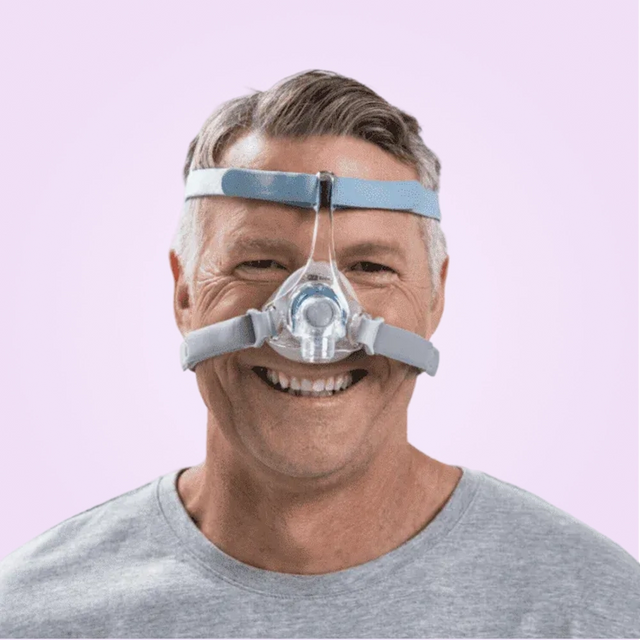 Man wearing a Fisher & Paykel Eson 2 Nasal CPAP Mask on a pink background