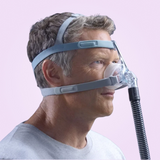 Side view of a man wearing a Fisher & Paykel Eson 2 Nasal CPAP Mask with a pink background