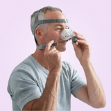 Man using a Fisher & Paykel Eson Nasal CPAP Mask on a pink background