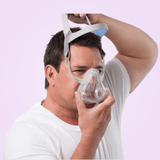 Man holding a ResMed AirFit™ F10 Full Face Mask against a light purple background