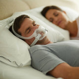 Man wearing a Philips Respironics DreamWear Full Face CPAP Mask while sleeping next to a woman.