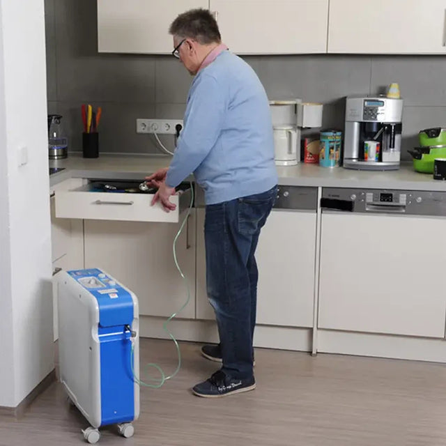 Person using a Kröber O2 Oxygen Concentrator in a kitchen setting