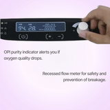 Philips Oxygenate 5 Home Oxygen Concentrator with digital display and hand interacting with it on a light purple background.