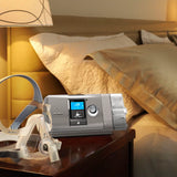 AirCurve 10 CS PaceWave Adaptive Servo-Ventilator with Humidifier next to a ResMed Quattro Air Full Face CPAP mask on a nightstand