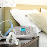 ResMed AirCurve 10 S BiPAP Device on a nightstand next to ResMed Quattro Air full face CPAP mask