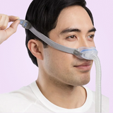 Man wearing a ResMed AirFit N30 Nasal CPAP Mask with a pink background