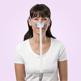 Woman wearing a ResMed AirFit N30 Nasal CPAP Mask on a pink background