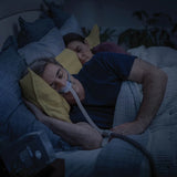 Two people lying in bed with one using a ResMed AirFit N30 Nasal CPAP Mask