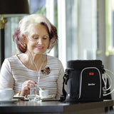 Woman using GCE Zen-O Lite portable oxygen concentrator while drinking coffee