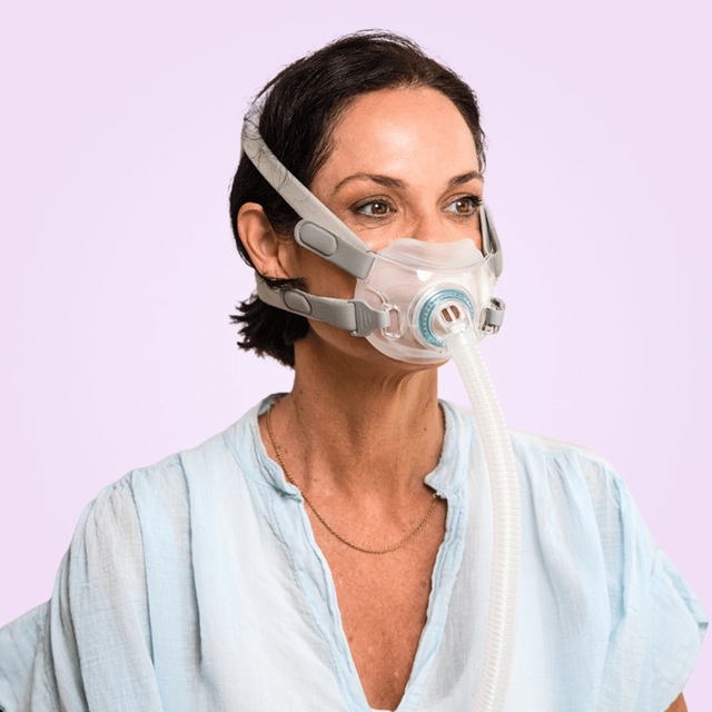 Woman wearing a BMC F6 Full Face CPAP Mask against a light purple background