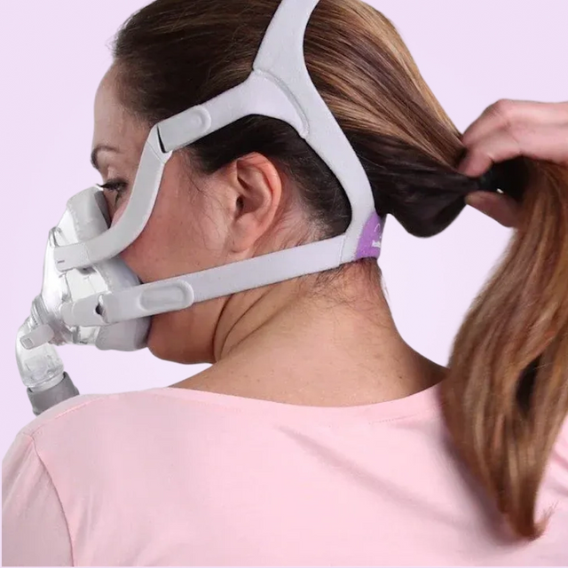 Woman wearing a white ResMed AirFit™ F20 For Her - Full-Face CPAP Mask