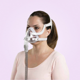 Woman wearing a ResMed AirFit™ F20 For Her - Full-Face CPAP Mask with a pink background